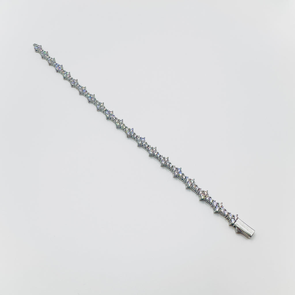 Silver bracelet with small diamonds on a light gray background
