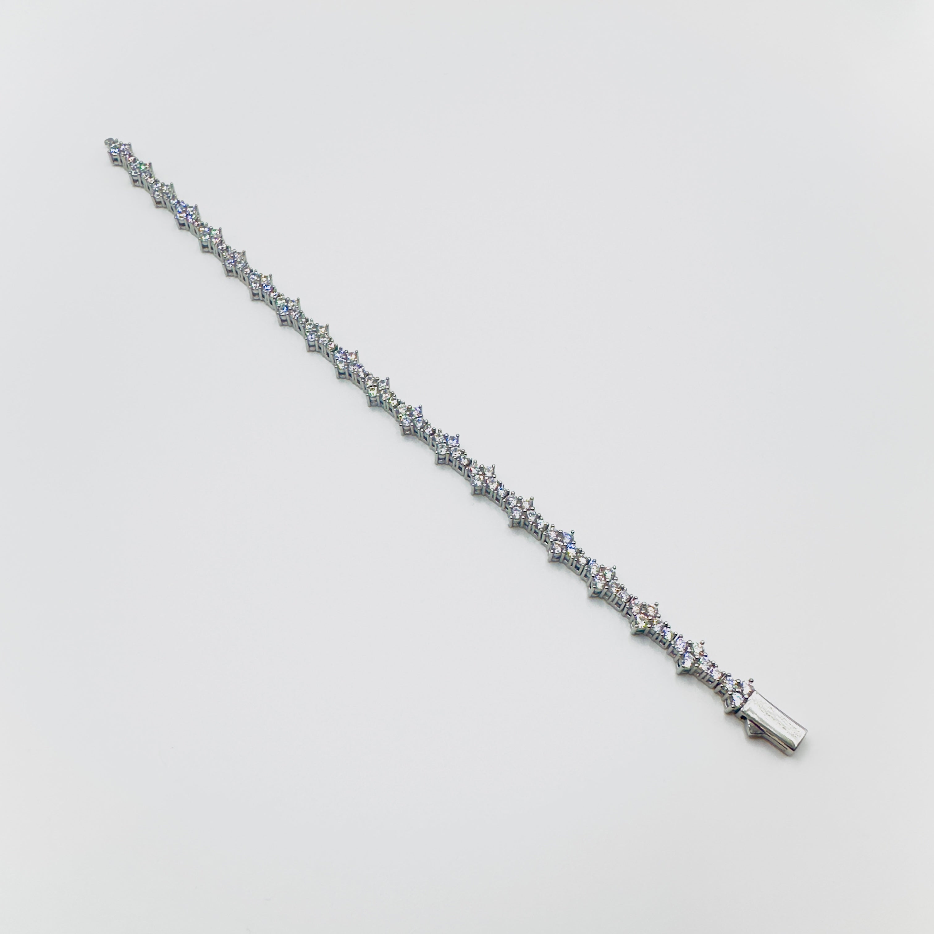 Silver bracelet with small diamonds on a light gray background